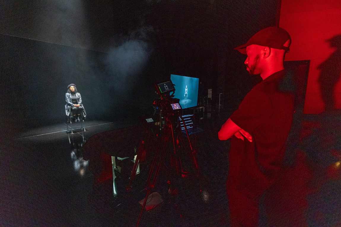 Davone behind the camera on the REC Live stage under red light