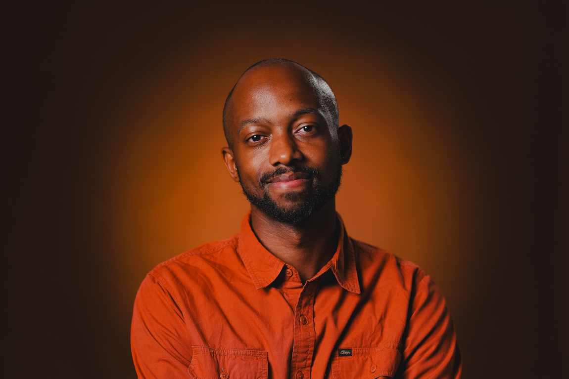 Portrait of Davone in an orange shirt